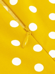 Gros plan d'une fermeture éclair invisible et de pois blancs sur une robe jaune pour fille