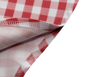 Macro shot of red and white vichy check fabric showing neat overlock stitching details