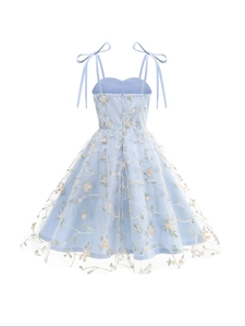 Détail de la robe en tulle bleu clair avec broderie florale rose et nœuds ajustables