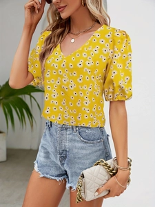 Detailed view of yellow V-neck floral blouse with delicate puff sleeves and daisy pattern