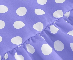 Detailed view of purple polka dot cotton fabric with ruffled texture for girls' dress