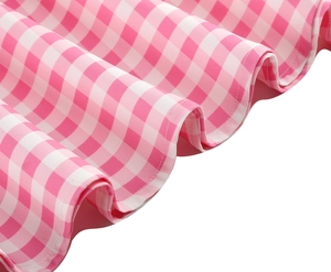 Detailed view of pink and white gingham dress hem featuring neat ruffle stitching