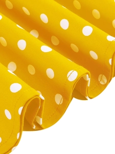Gros plan du tissu jaune à pois blancs montrant les coutures et les détails de texture