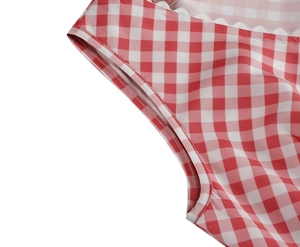 Detail of red and white gingham dress featuring scalloped lace trim and quality stitching