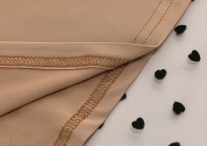 Detail of polka dot mesh stitching with neat seams and heart-shaped flocking fabric