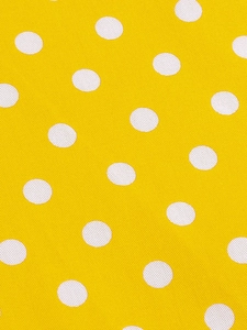 Détail du tissu jaune à pois blancs montrant la texture lisse et le motif imprimé