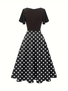 Robe trapèze vintage à pois avec corsage noir et manches volantées sur fond blanc