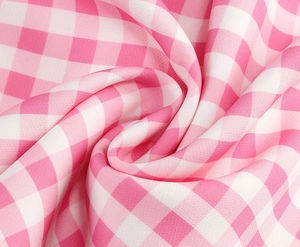 Close-up of pink and white gingham fabric with soft texture and vibrant plaid pattern