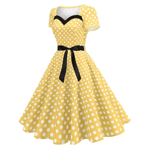 Detail of yellow polka dot vintage dress with sweetheart neckline and black bow belt
