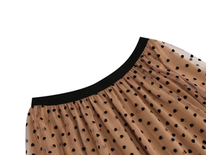 Detail of a-line mesh skirt featuring black flocked heart patterns and elastic waistband