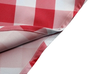 Gros plan sur tissu vichy rouge et blanc montrant les coutures de l'ourlet et la texture