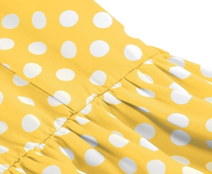 Vue macro d'une robe jaune à pois montrant les coutures détaillées et la texture plissée