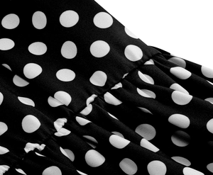 Macro dettagliata del motivo a pois vintage su tessuto nero con elegante trama a pieghe