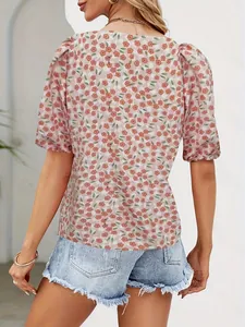 Rear view of floral puff sleeve top paired with frayed denim shorts in bright daylight
