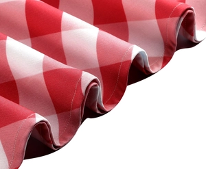 Vue détaillée du tissu à carreaux rouge et blanc avec des ourlets finement cousus