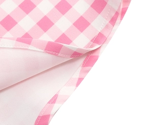 Detail of pink gingham fabric dress showing clean stitching and soft inner lining