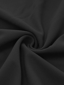 Close-up of black polka dot dress fabric with elegant ruffled chiffon texture