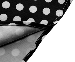 Dettaglio dell'orlo a doppia cucitura e motivo a pois bianchi sull'abito vintage
