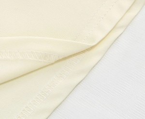 Detail of the high-quality double-needle overlock stitching on a beige dress hem