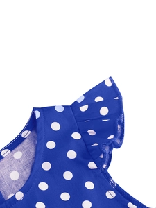 Détail de la robe à pois bleu roi montrant les manches volantées et les coutures de qualité