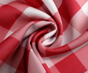 Détail macro du tissu vichy rouge et blanc montrant la texture douce et le tissage