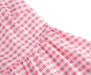 Detail of pink and white gingham fabric featuring delicate ruffled smocking and fine stitching