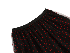 Detailed view of black mesh skirt featuring red velvet heart patterns and elastic waistband