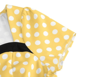Detailed view of yellow polka dot dress showing bubble sleeves and black contrast panels
