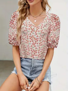 Detailed view of pink floral puff sleeve V-neck blouse with blue denim shorts