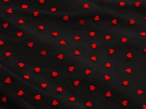 Macro shot of black mesh fabric featuring textured red flocked heart patterns