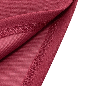 Détail des coutures uniformes et texture sur le tissu de robe bordeaux ajustée