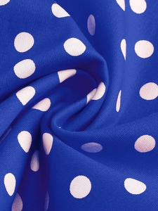 Vue macro détaillée du tissu bleu roi à pois blancs avec une texture lisse et soyeuse