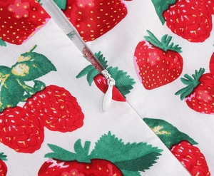Detailed macro view of invisible zipper and strawberry print on white girl's dress fabric