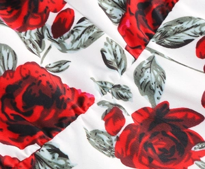 Close-up of red rose floral print on white cotton fabric with fine sewing details