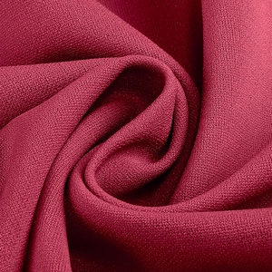 Vue macro du tissu mousseline rouge foncé avec drapé fluide et fini mat élégant