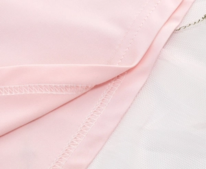 Detailaufnahme von rosa Jerseystoff und weißen Netzschichten mit feiner Naht