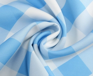 Gros plan sur un tissu à carreaux bleu et blanc avec texture lisse et drapé souple
