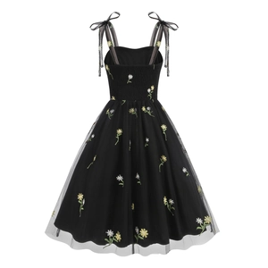 Detailed view of yellow and white daisy floral embroidery on black mesh tulle dress