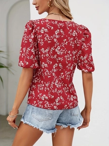 Back view of a red floral crop top with puff sleeves paired with frayed denim shorts
