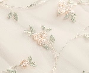 Gros plan sur tissu en tulle avec broderie 3D et motifs floraux délicats