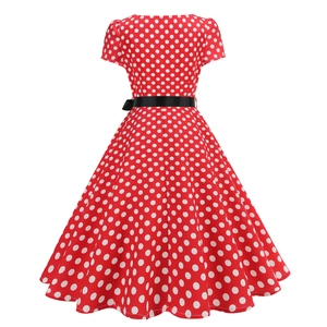 Close-up of vintage red polka dot dress featuring a black waist belt and flared A-line skirt