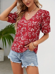 Detail view of summer floral V-neck blouse with elegant puff sleeves and feminine pattern