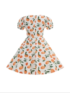 Detail of girls' white summer dress with realistic orange fruit prints and puff sleeves
