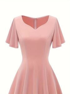 Detailed view of pink V-neck dress featuring ruffle cap sleeves and a tailored waistline