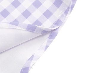 Detail view of pink gingham dress fabric with neat stitching and white lining