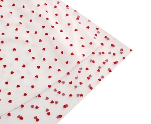 Close-up of white mesh fabric featuring red heart patterns and delicate lace texture