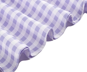 Detail of purple and white gingham fabric with refined ruffle edges and stitching