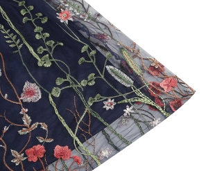 Detailed close-up of colorful floral embroidery on navy blue mesh tulle dress fabric