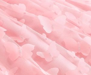 Dettaglio macro del tessuto in tulle rosa con farfalle 3D e rifiniture glitterate argento