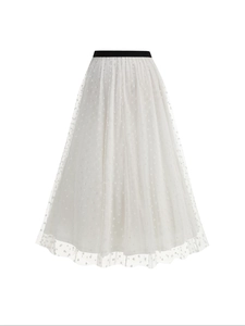 Detail of white mesh skirt featuring flocked polka dots and a black elastic waistband